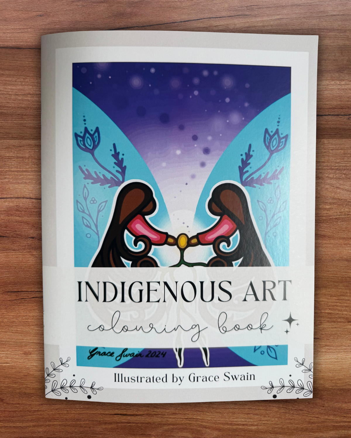 Indigenous Art coloring book on a wooden surface
